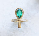 An emerald and diamond ankh ring with natural gemstones and baguette diamonds.