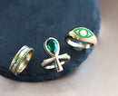 An ankh ring with emerald and diamond details, showcasing exquisite craftsmanship.