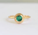 Emerald Ring: A gold solitaire ring featuring a vibrant green gem. Elegantly designed for special occasions.