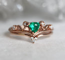 Vintage emerald and diamond ring set in 14k or 18k rose gold. Trillion emerald center stone with surrounding white diamonds.