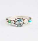 Blue round sapphire cluster ring with turqoise, emerald, opal and diamond stones