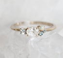 Oval-shaped white diamond cluster ring with sapphire, opal and topaz stones