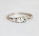 Oval-shaped white diamond cluster ring with sapphire, opal and topaz stones