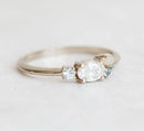 Oval-shaped white diamond cluster ring with sapphire, opal and topaz stones