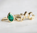 Close-up of Pear Emerald Ring with pear-cut Emerald solitaire design. Stone: Emerald, Shape: Pear, Color: Green. Band: Style: Solitaire, Material: 14k/18k Gold, Platinum.
